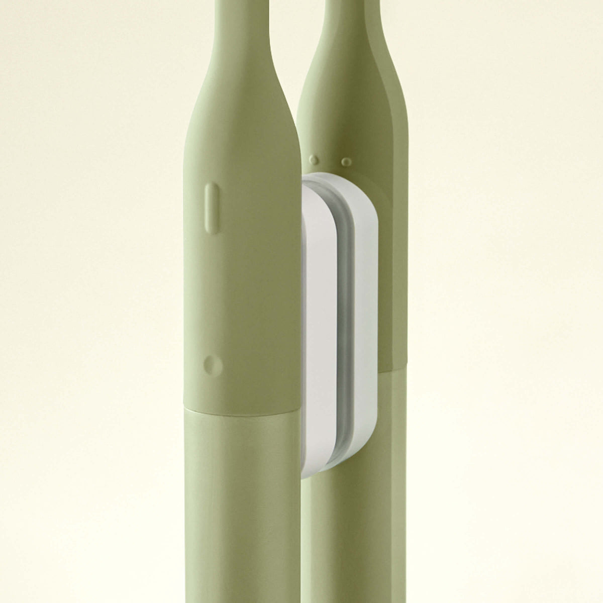 Two green electric toothbrushes with a white base on a beige background